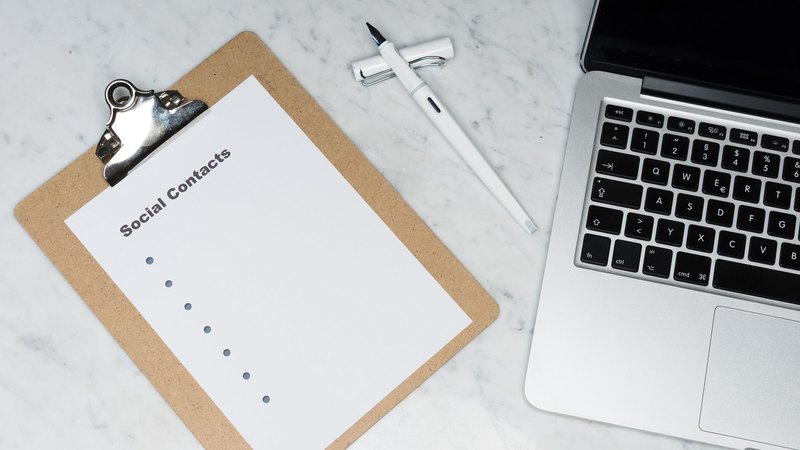 Clipboard, pen and laptop on a marble desk — illustrative workspace